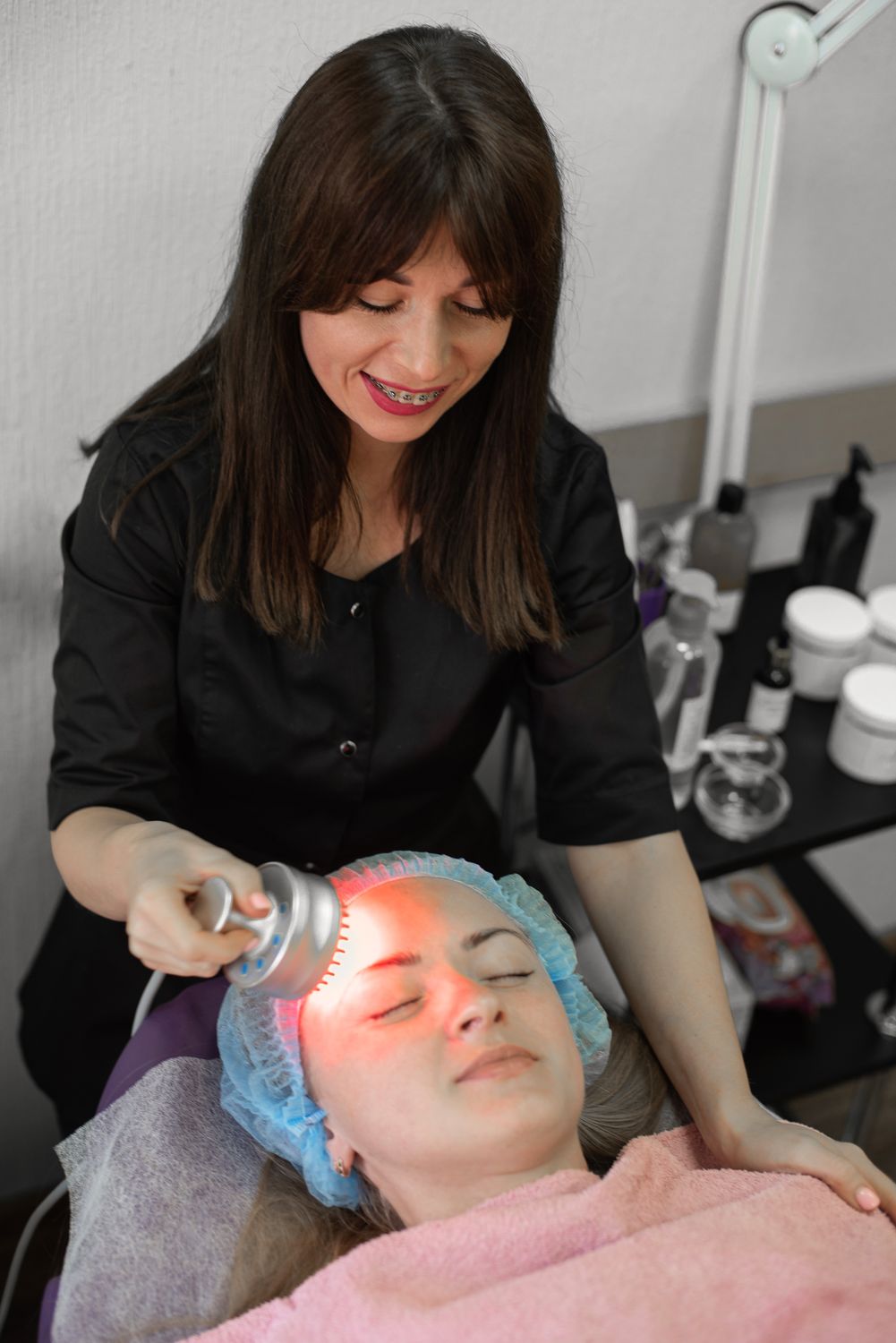 Woman using LED light therapy for anti-aging skincare - PeakForm